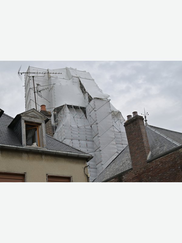 Verhüllter Kirchturm aus der Nähe mit Taube und Plüschtier